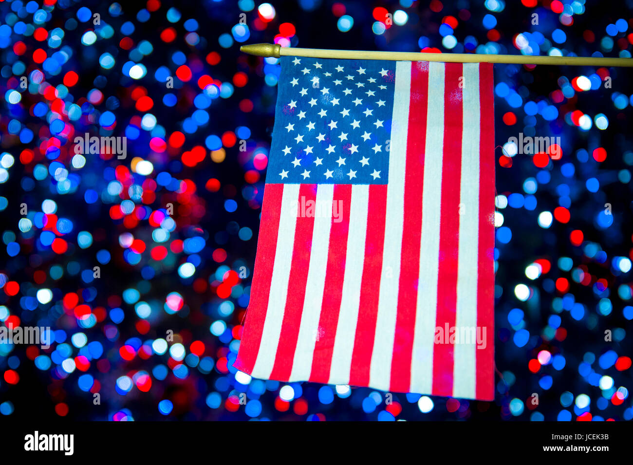 Amerikanische Flagge hängt vor festlichen Bokeh Hintergrund in rot, weiß und blau Stockfoto