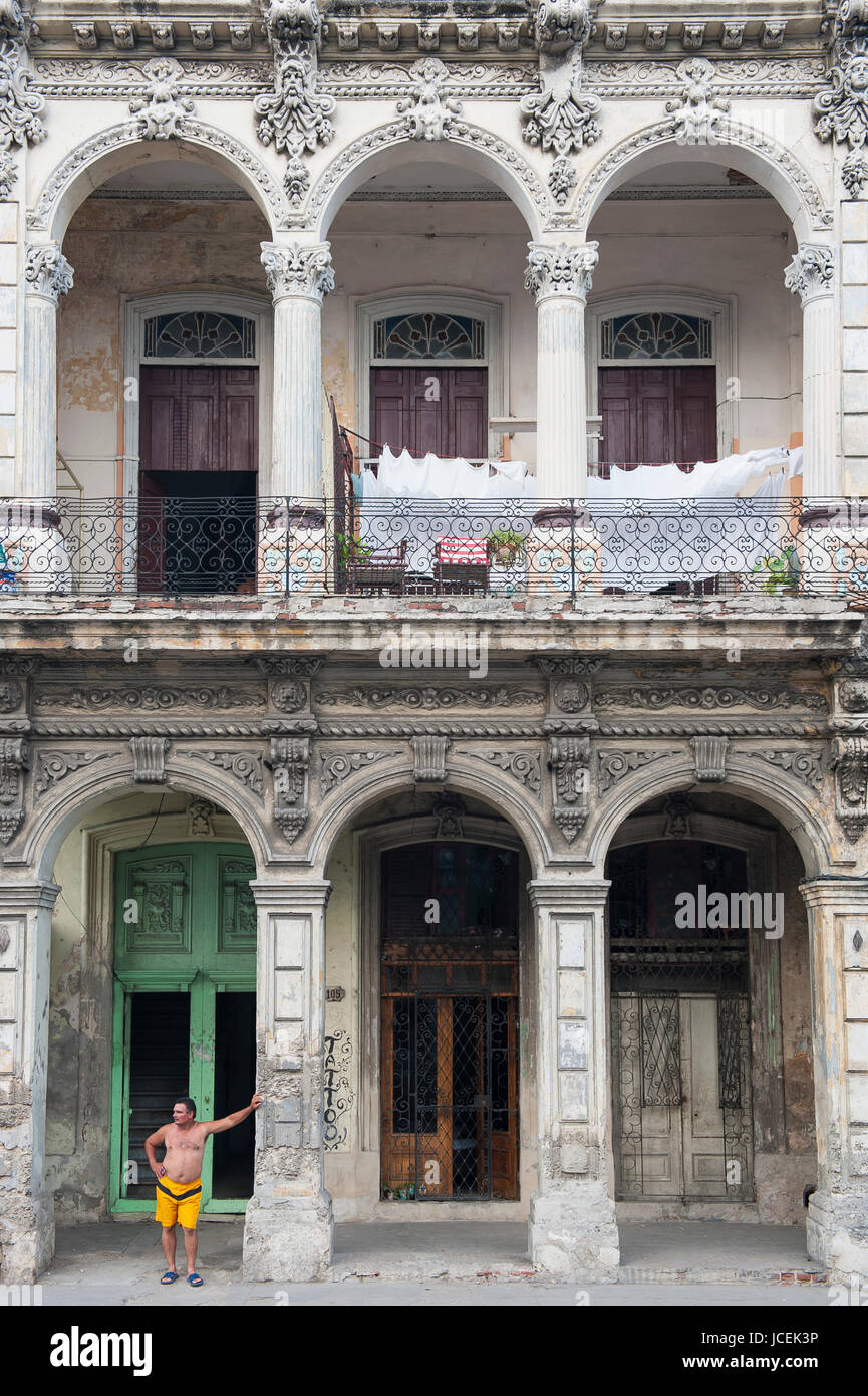 Havanna - ca. Juni 2011: Kubanische Mann steht zwischen den Bögen aus einer verfallenen Reihe von kolonialen Gebäuden in einem Wohnviertel im Zentrum Stadt Stockfoto