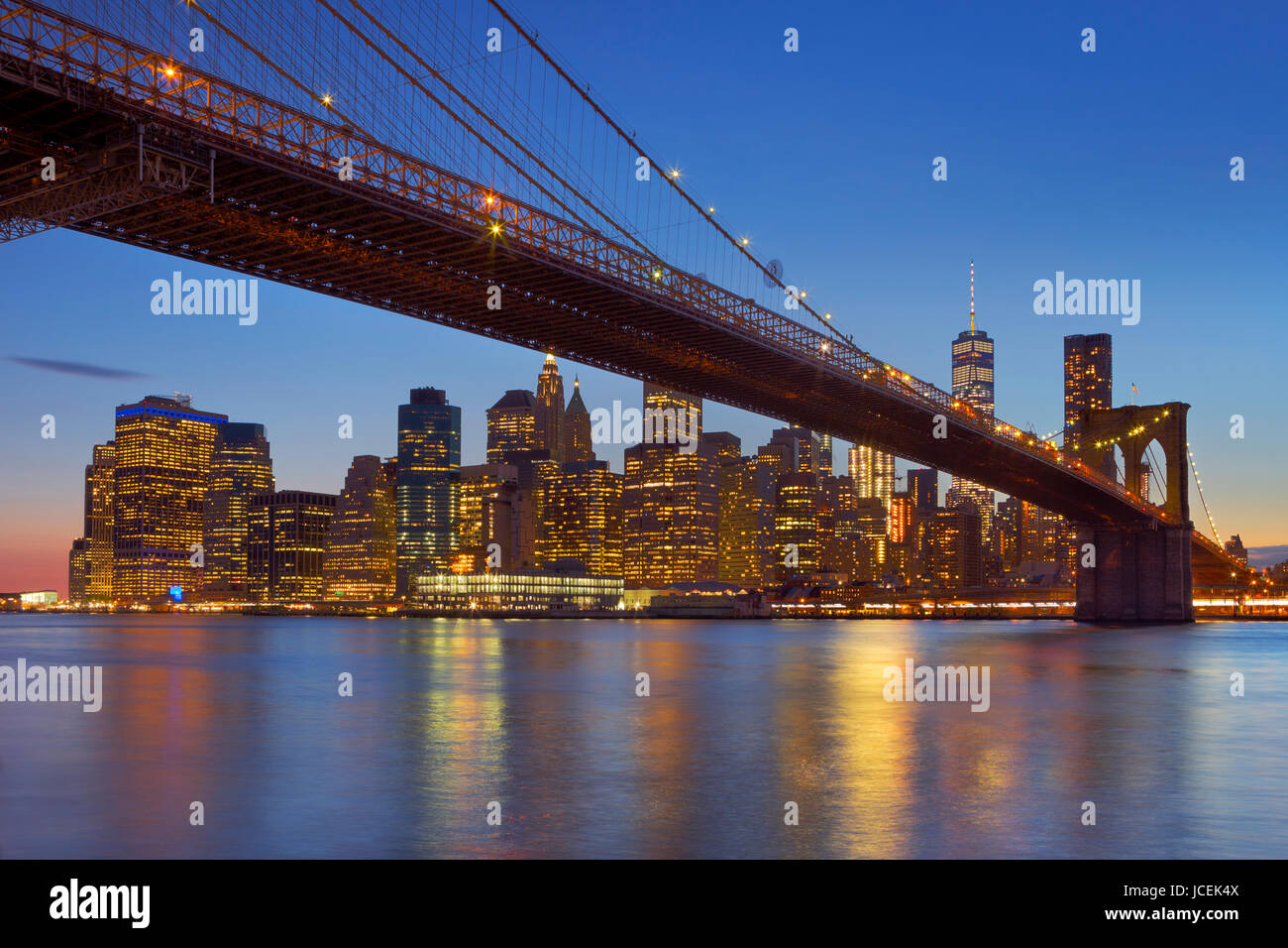 Brooklyn Bridge mit der New Yorker Skyline im Hintergrund, in der Dämmerung fotografiert. Stockfoto