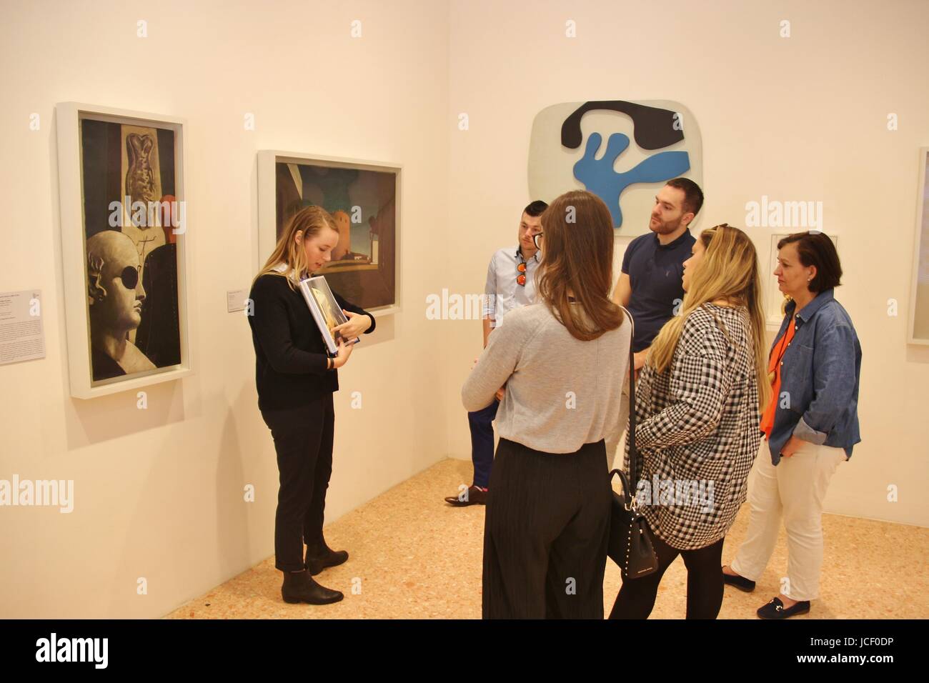 Ein Museumsführer erläutert einige herausragende zeitgenössische Gemälde für die Besucher. In den Räumen der Peggy Guggenheim Collection, Venedig, Italien, Europa. Stockfoto