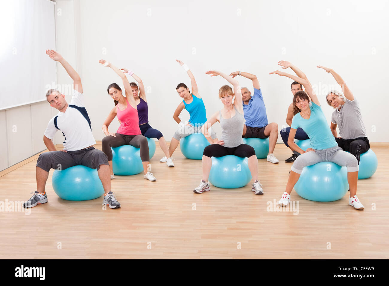 Große Gruppe von verschiedenen Menschen in einer Pilates-Klasse-Turnen in der Turnhalle üben Balance und Kontrolle Stockfoto