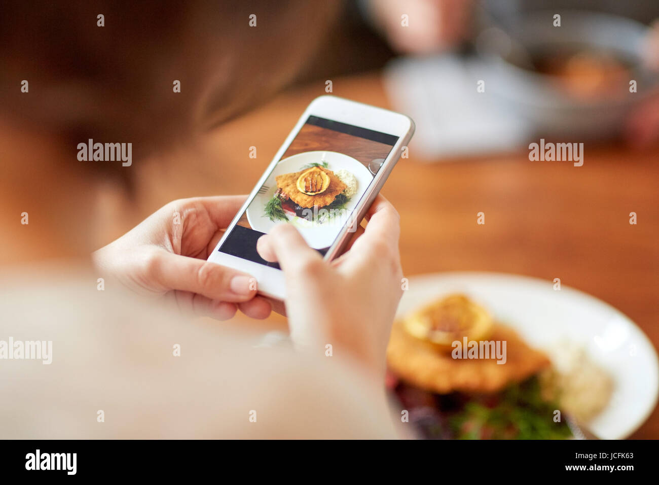 Frau mit Smartphone fotografieren Essen im café Stockfoto