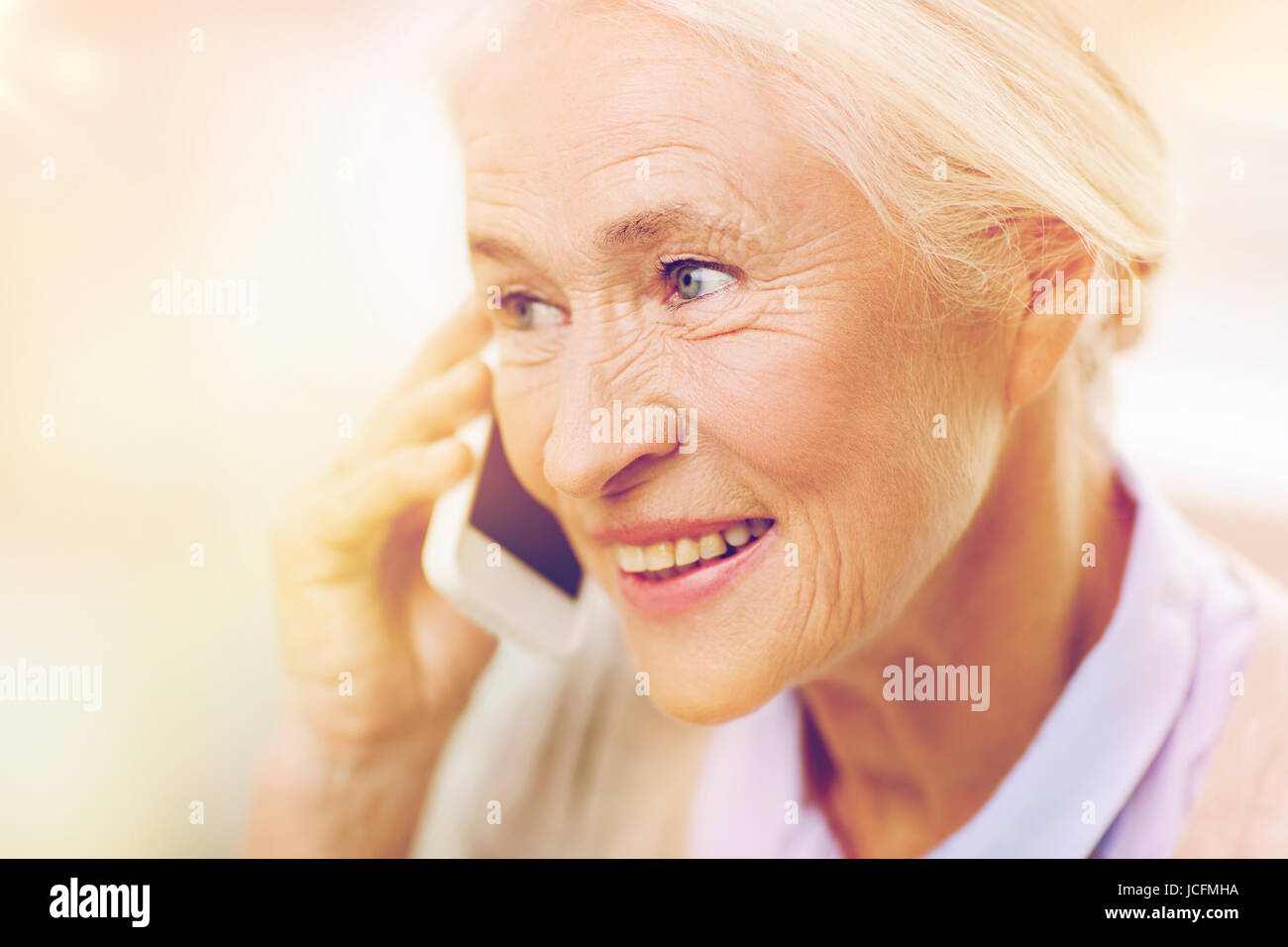 ältere Frau mit Smartphone zu Hause anrufen Stockfoto