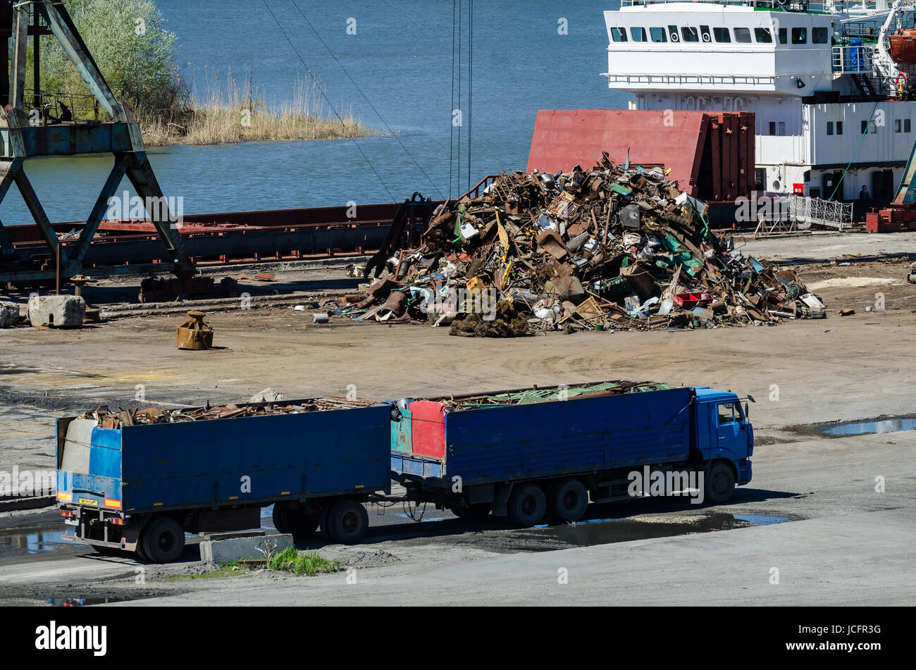 Kranich im Binnenhafen. Schwere Kräne entladen Metall zu importieren. Stahl Lieferung Stockfoto