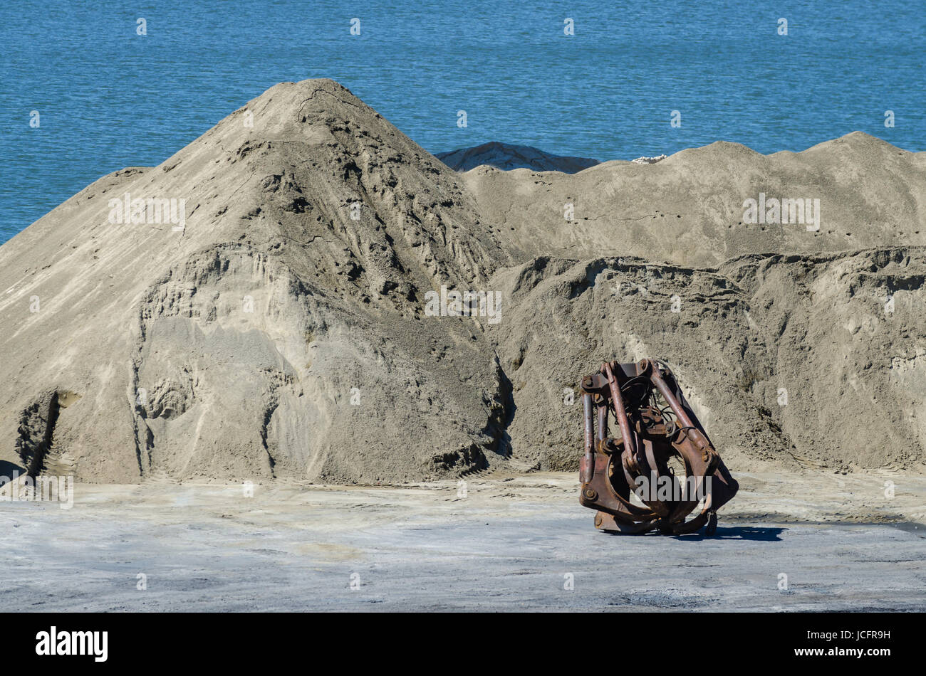 Krankopf im Binnenhafen. Schwere Kräne entladen Sand für Bussiness. Ressourcen-Lieferung Stockfoto