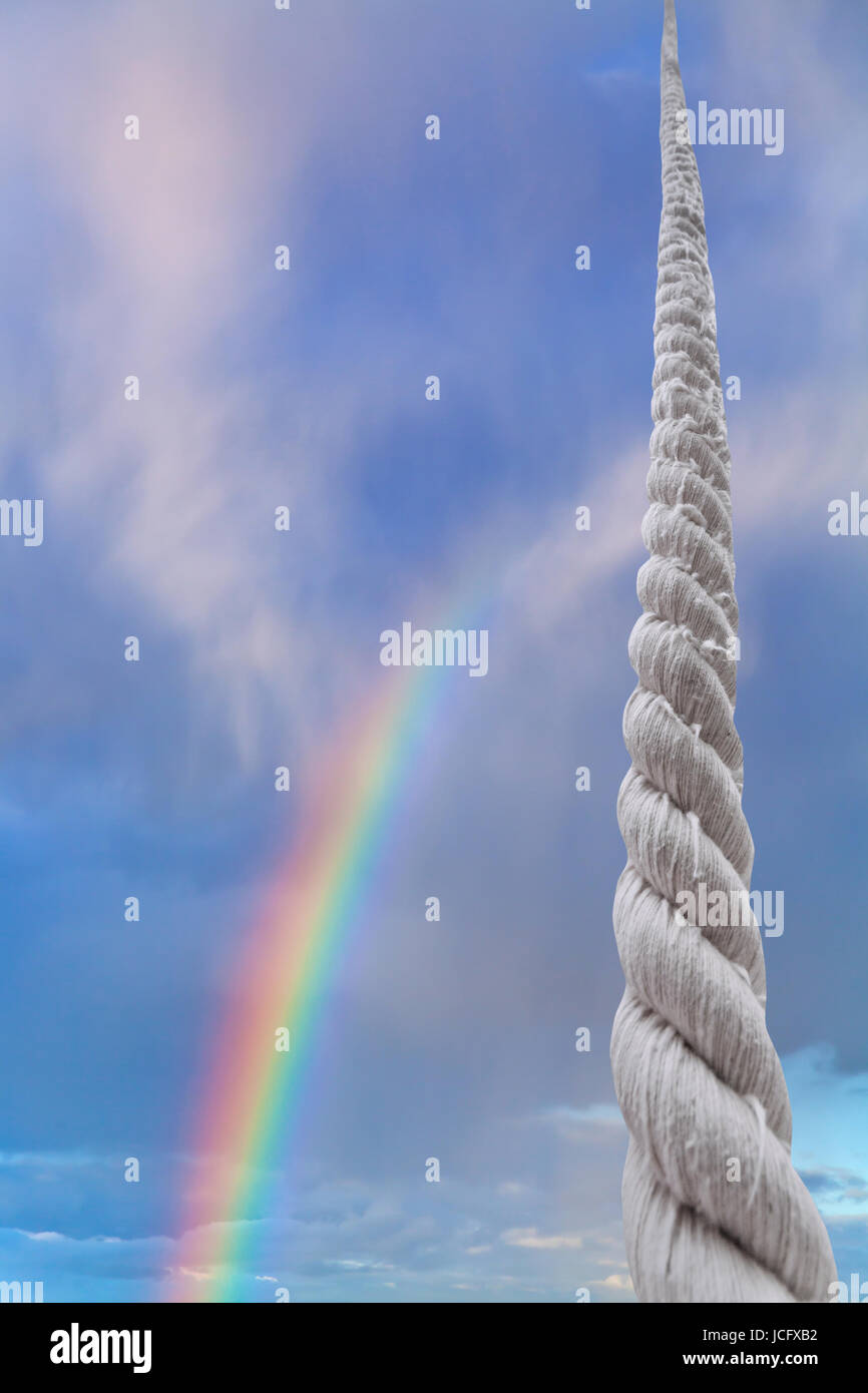 dicke Schnur steigt in blauer Himmel mit Regenbogen Stockfoto