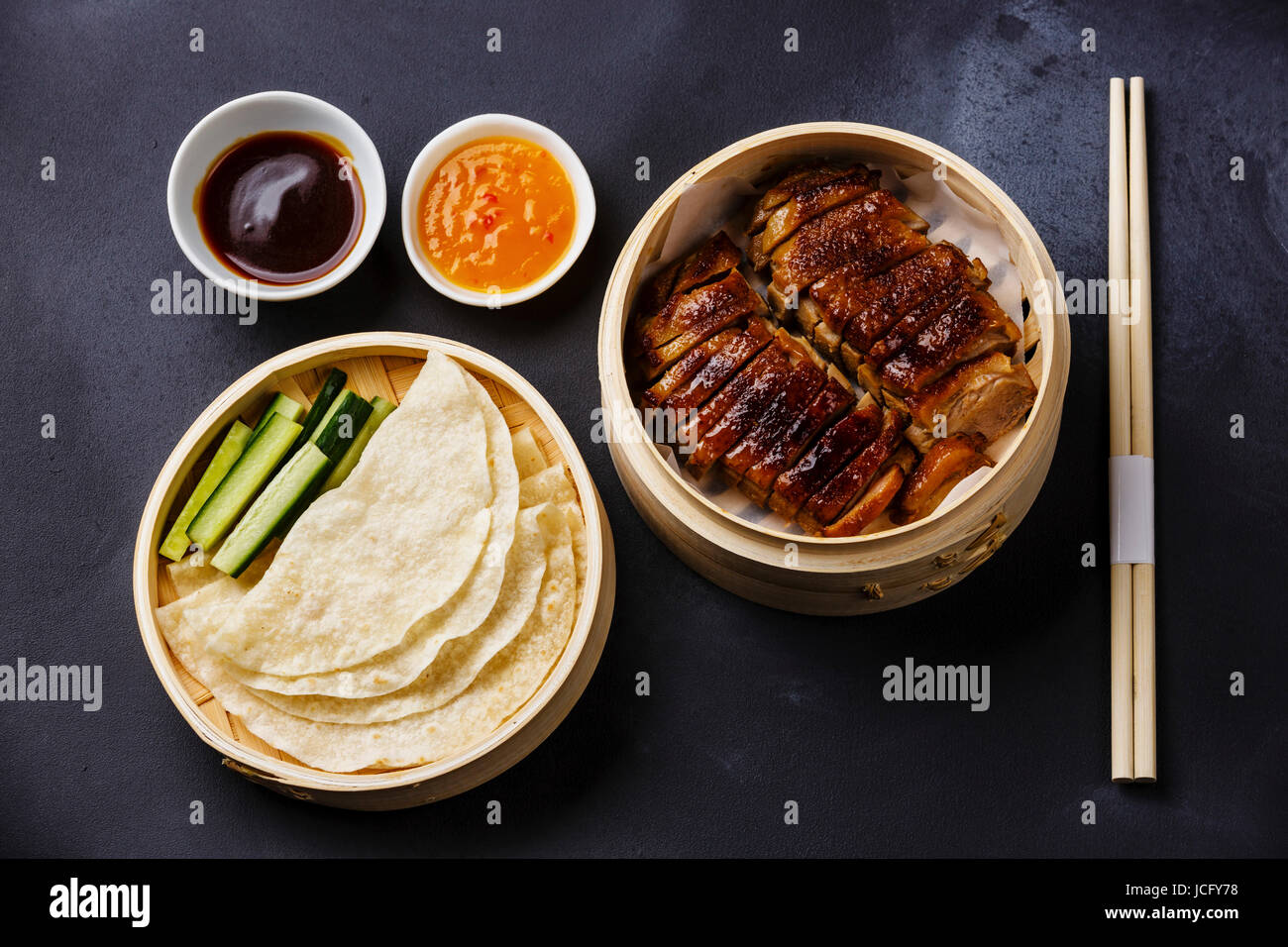 Peking-Ente in Bambus Dampfgarer serviert mit frischer Gurke, Sauce und ...