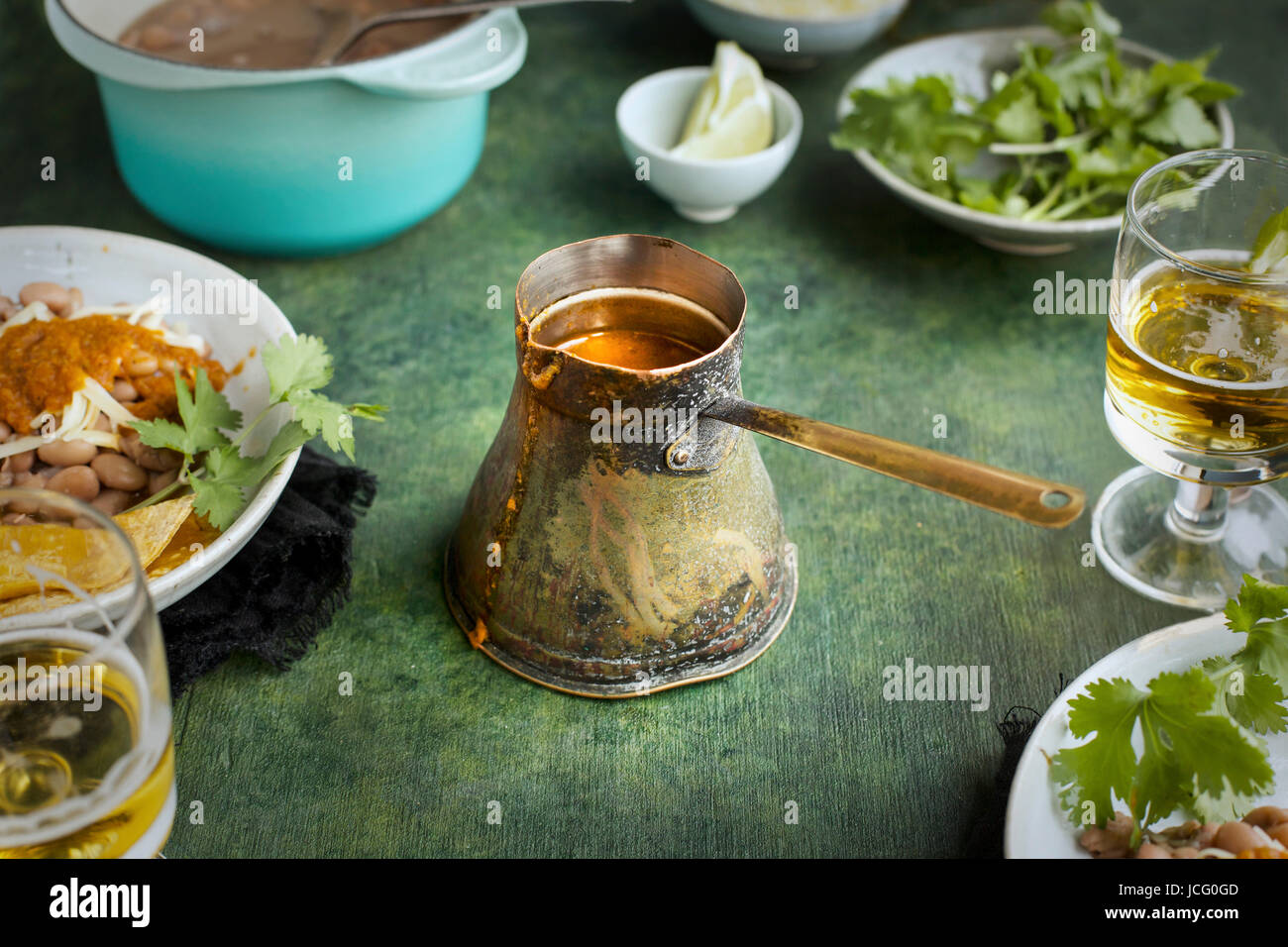 Ranchero-Sauce in einer Vintage Kupfer Kelle.  Auf einem grünen Hintergrund fotografiert. Stockfoto