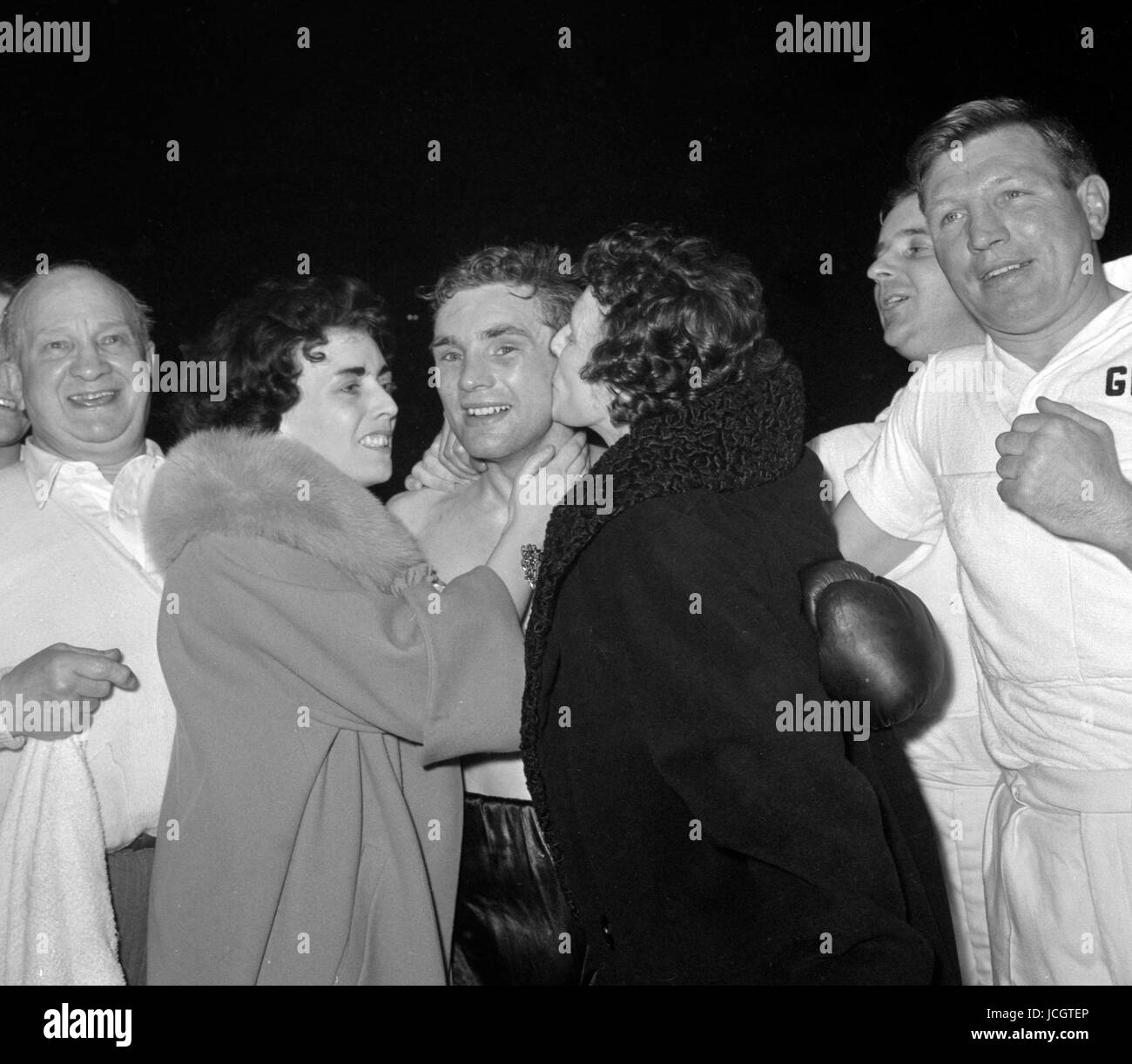 Einen Kuss von seiner Mutter, einer Umarmung von seiner Frau für Howard Winstone, von Merthyr Tydfil, Großbritanniens neuer Weltmeister im Federgewicht, in den Ring am Empire Pool, Wembley. Stockfoto