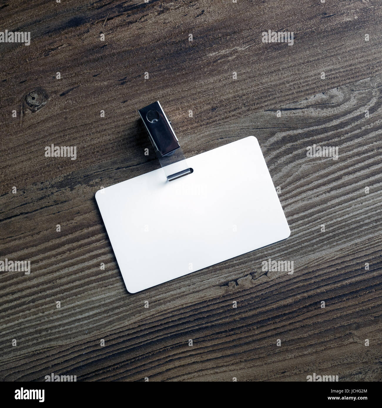 Foto von leeren weißen Kunststoff-Abzeichen auf Holztisch Hintergrund. Leere ID-Karte. Vorlage für Ihr Design. Ansicht von oben. Stockfoto