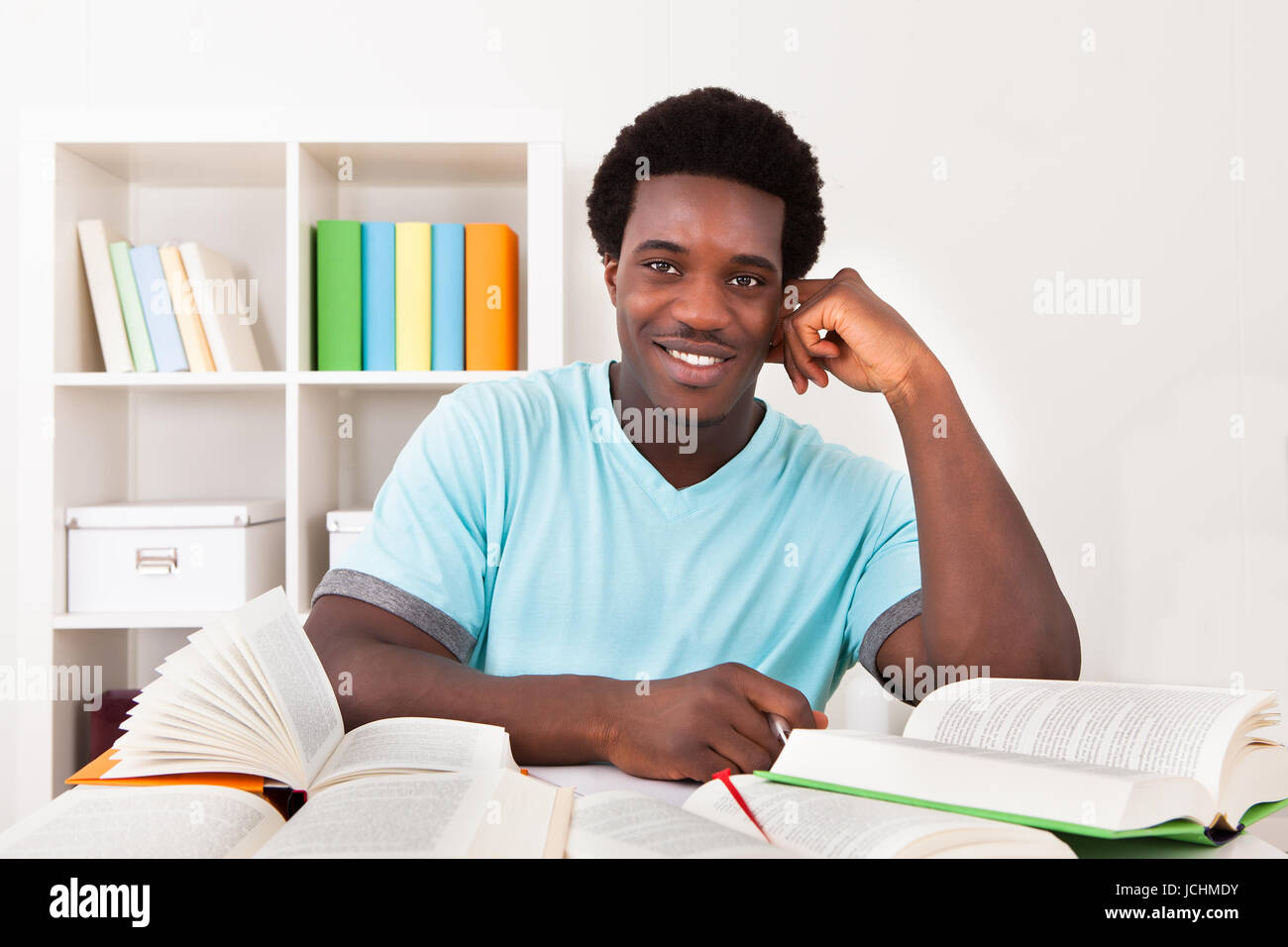Junge Afrikaner Studium zu Hause mit eine Menge Bücher Stockfoto