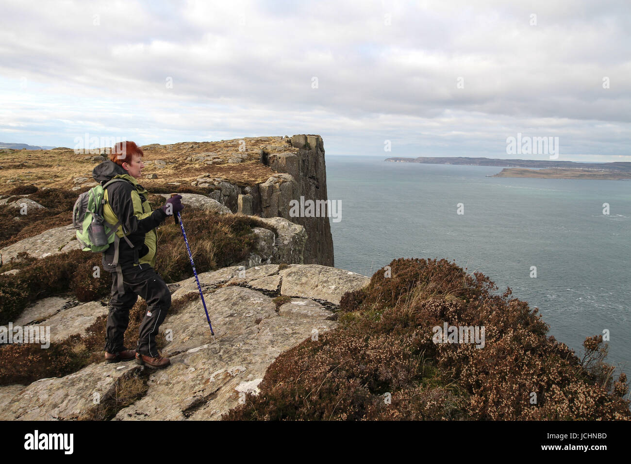 Eine Hügel-Walker blickt auf das Meer vom Klippe Weg zu Fair Head, Ballycastle, County Antrim, Nordirland. Stockfoto