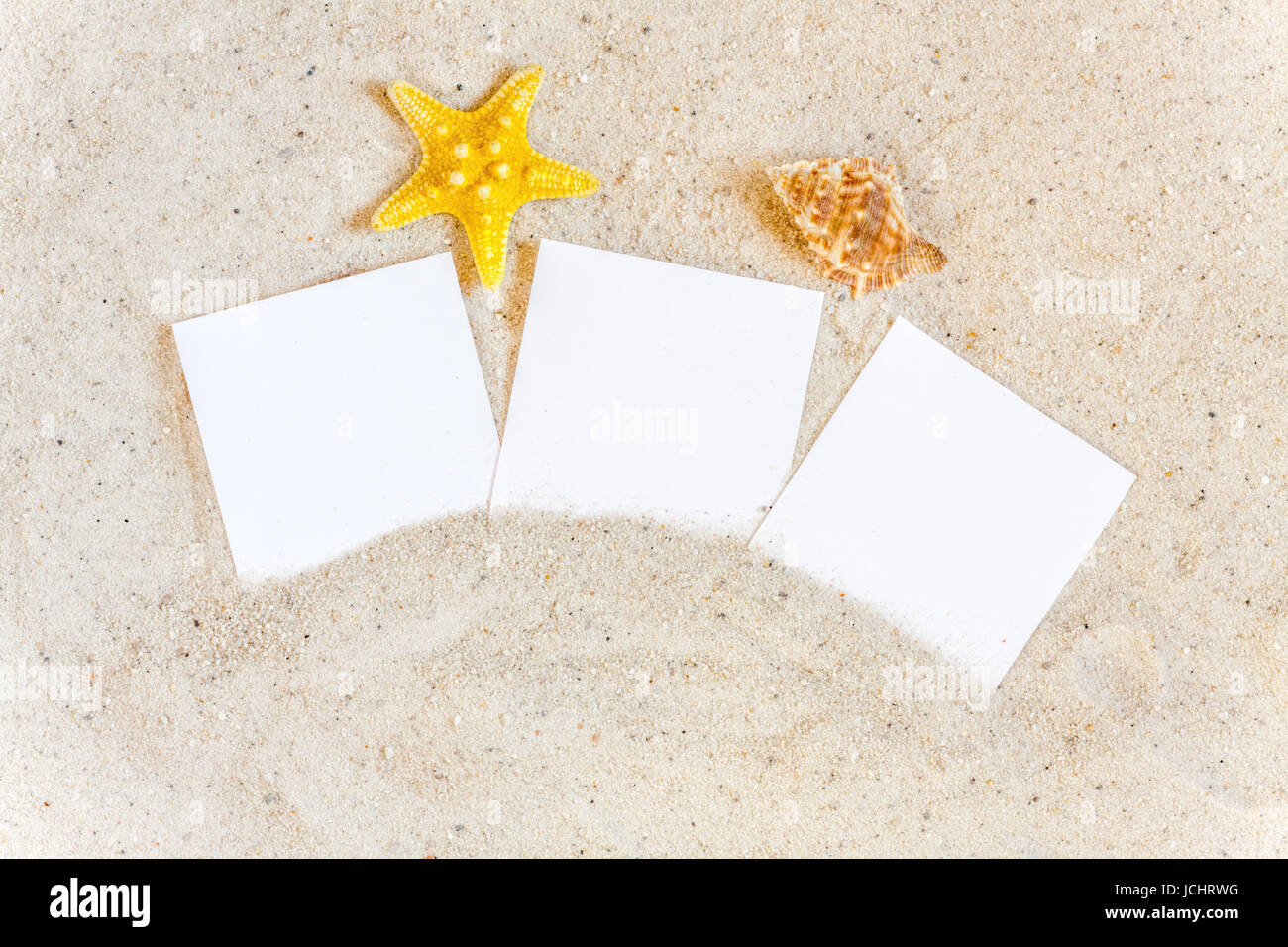 Drei Leere Sofortbilder Stück Mit Muscheln Im Sand Stockfoto