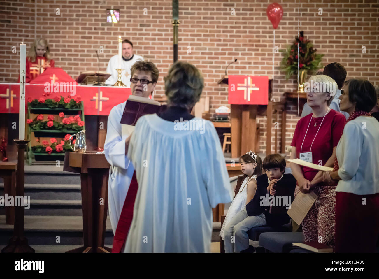 Kirchliche Trauung, Taufe von Kleinkindern.  Eltern, Großeltern, Freunde und verwandte anwesend. Religiöse Feier. Stockfoto