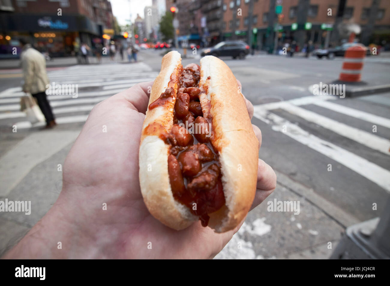 Mann mit Chili Hot Dog Essen in New York City, USA Stockfoto