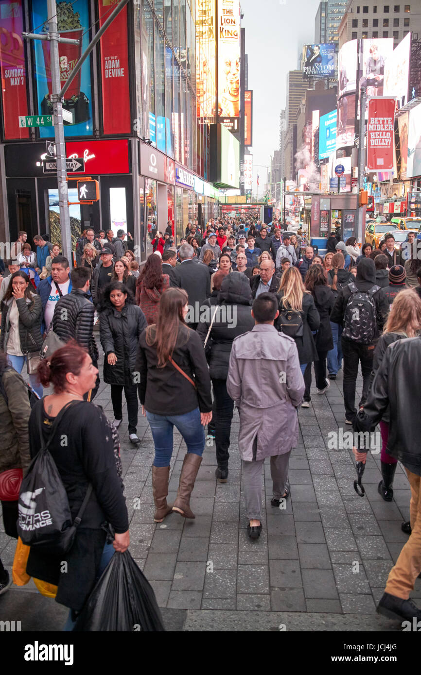 Menschen überqueren Zebrastreifen voll beschäftigt Bürgersteig am Abend Abend in Times Square New York City USA Stockfoto