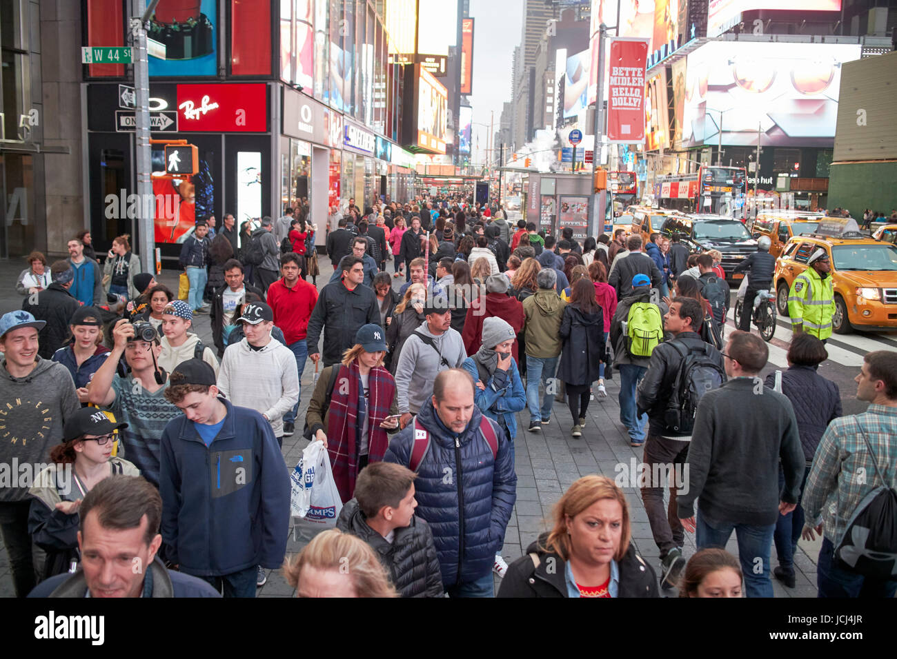 Menschen überqueren Zebrastreifen voll beschäftigt Bürgersteig am Abend Abend in Times Square New York City USA Stockfoto