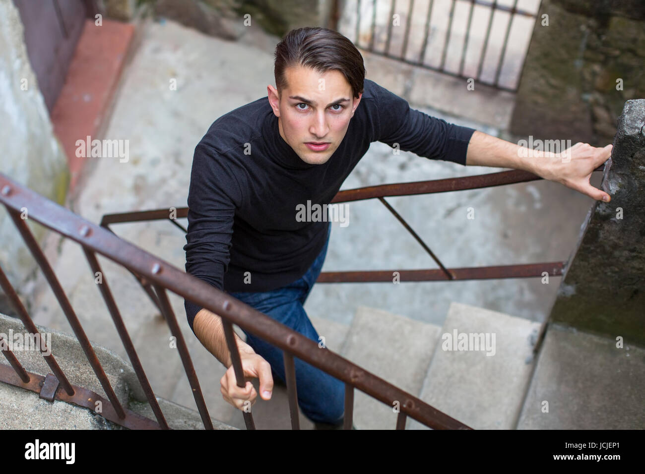 Porträt des jungen Kerl auf der Treppe in der Altstadt. Stockfoto
