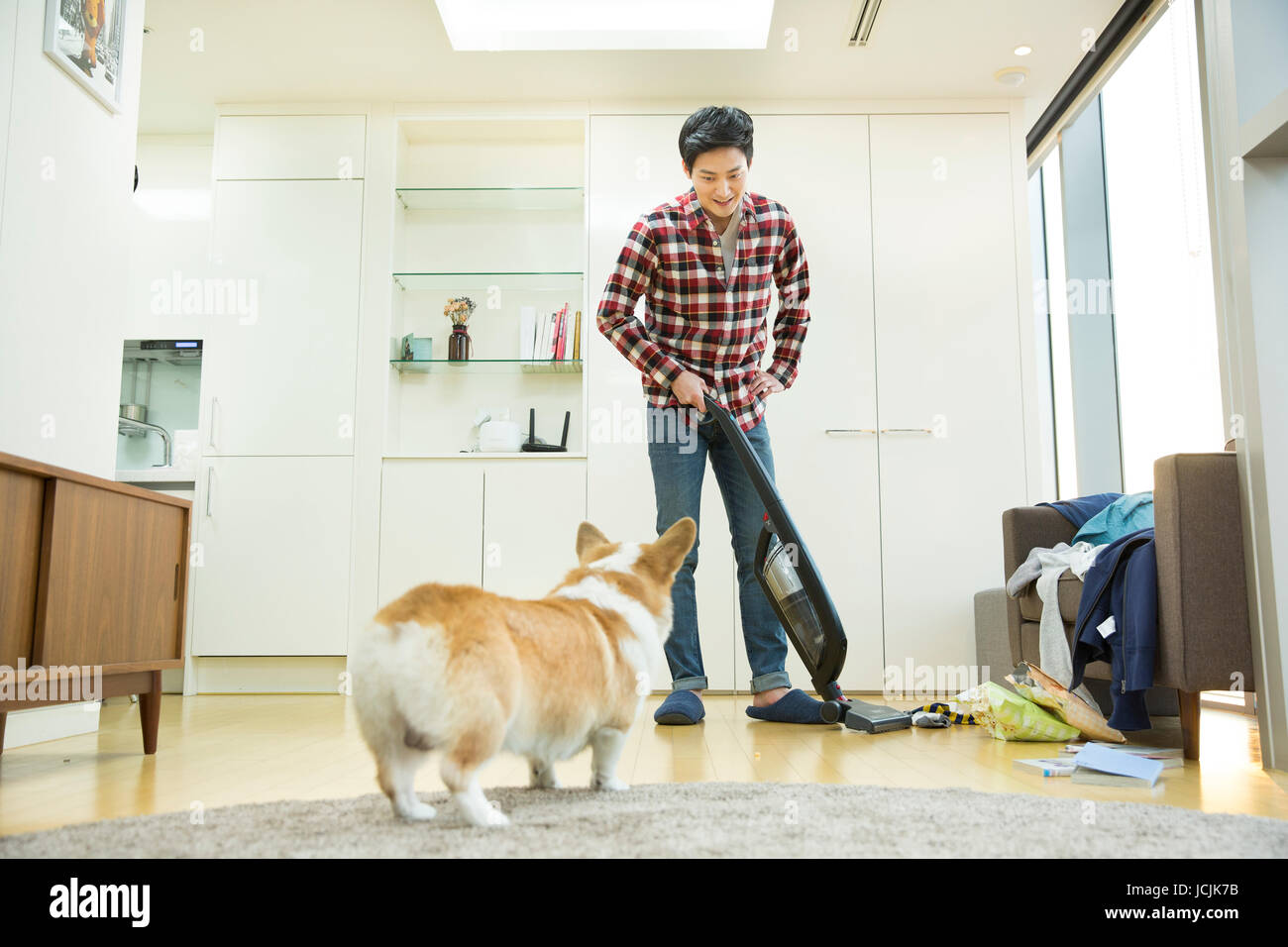 Junge Bachelor mit einem Haustier Hund sein Haus Reinigung Stockfoto