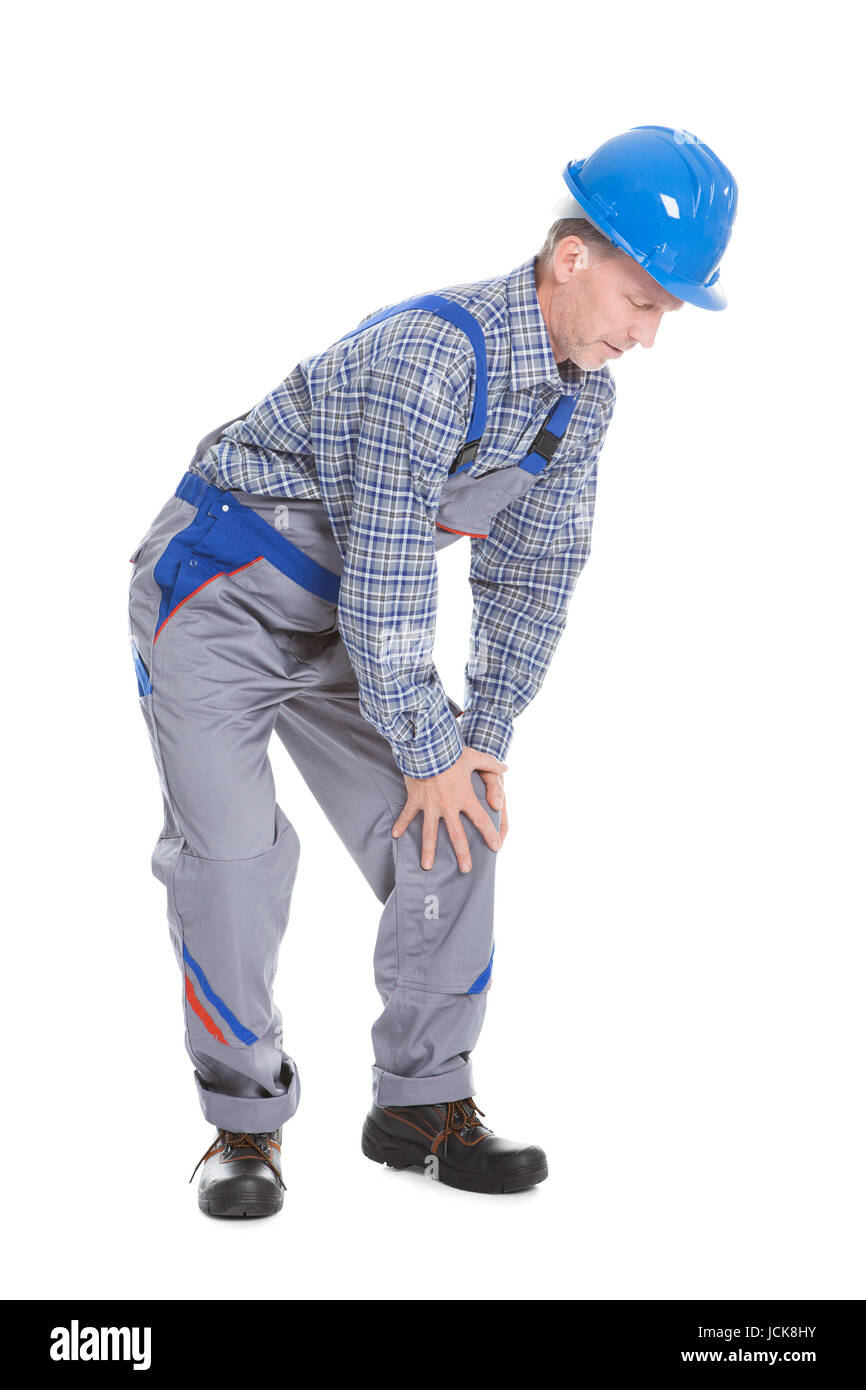 Reifen männlichen Arbeitnehmer leiden unter Schmerzen im Knie Isolated Over White Background Stockfoto