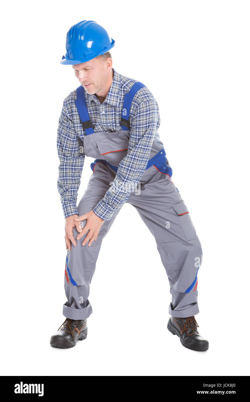Reifen männlichen Arbeitnehmer leiden unter Schmerzen im Knie Isolated Over White Background Stockfoto