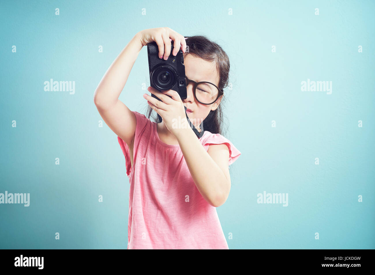 Porträt von niedlichen asiatische Mädchen nehmen Bildchen mit Retro-Kamera im Studio auf Vintage Mint grünen Hintergrund. Stockfoto