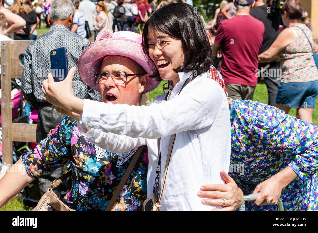 England, Coxheath. Welt Custard pie Meisterschaften. Lachend japanische Mädchen unter selfie mit einem Team des Grannie, Männer, verkleidet als alte Damen. Stockfoto