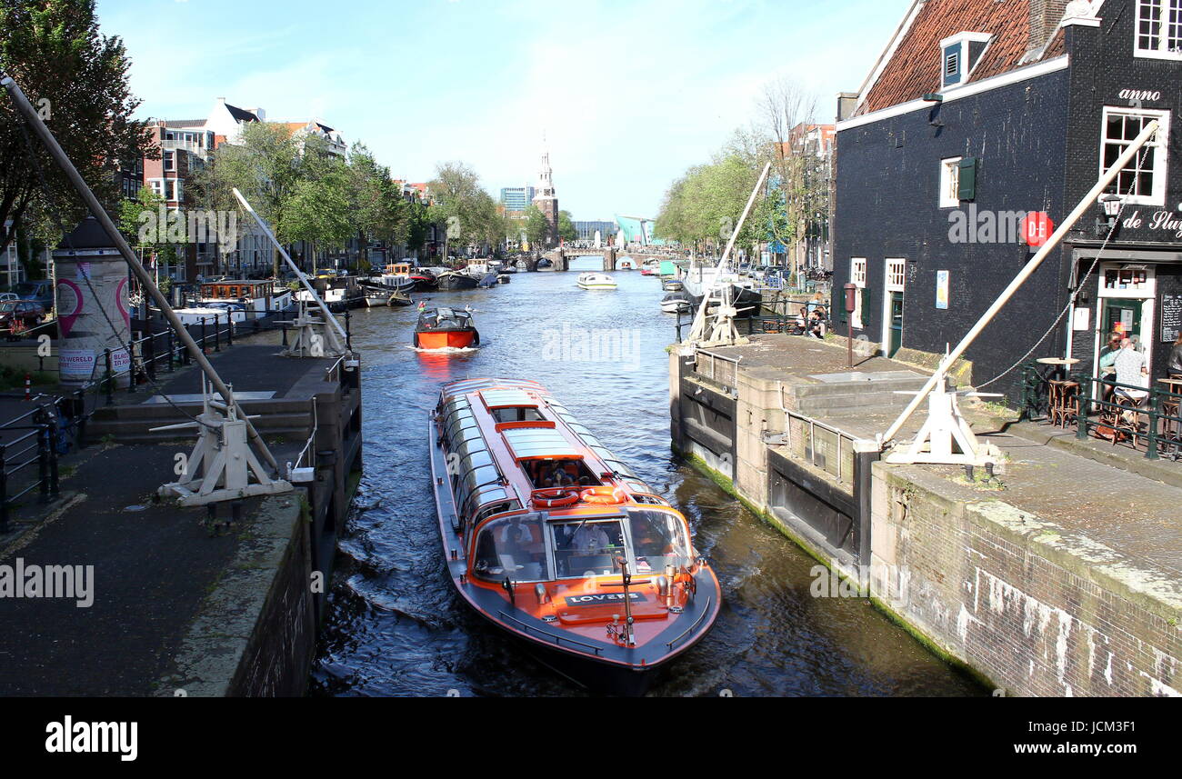 Kanalboot Sint Antoniesluis Sperre zwischen Zwanenburgwal & Oudeschans Canal, Amsterdam, Niederlande, mit Café De Sluyswacht (Goslerhuisje) vorbei. Stockfoto
