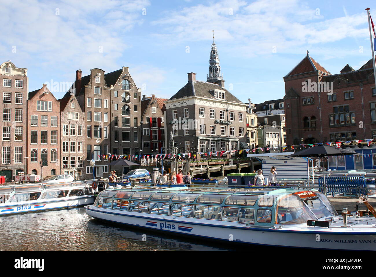 Grachtenfahrt Boot vertäut am Damrak Wasserstraße, zentrale Amsterdam, Niederlande. Stockfoto