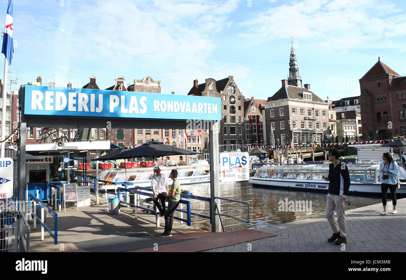 Grachtenfahrt Boot vertäut am Damrak Wasserstraße, zentrale Amsterdam, Niederlande. Grachtengürtels Plas Rondvaarten Stockfoto