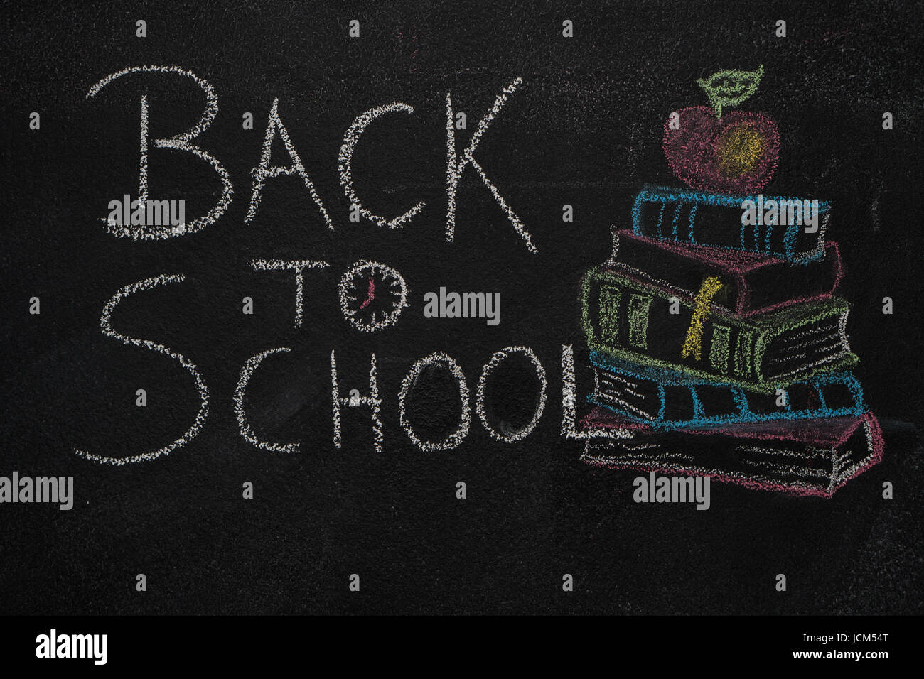Zurück zur Schule Text und Stapel Bücher mit Apple mit Kreide auf die Tafel gezeichnet. Bildung, Schulkonzept Stockfoto
