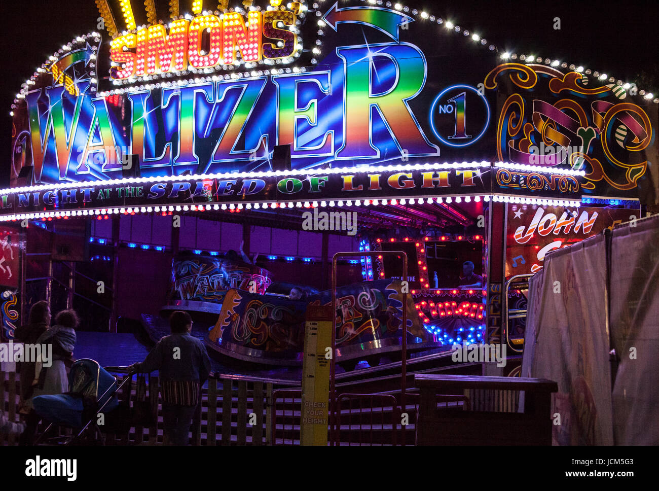 Fahrgeschäfte auf der Kirmes nachts beleuchtet Stockfoto