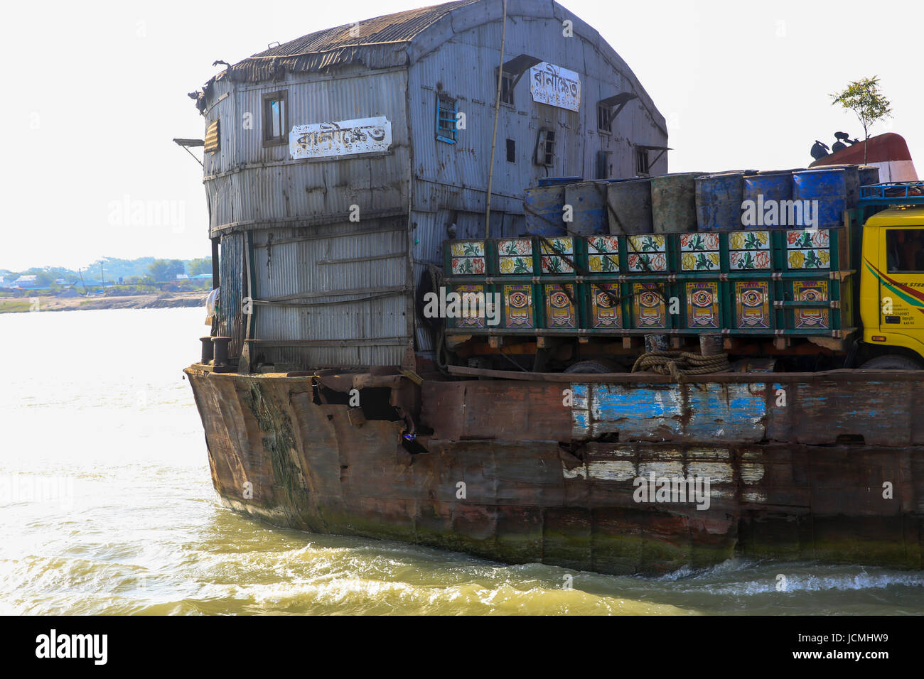 Bangladesh Inland Water Transport Corporation der (BIWTC) stumm Fähren trägt eine große Last auf seinem zerfetzten Körper über den mächtigen Padma-River. Munshigan Stockfoto