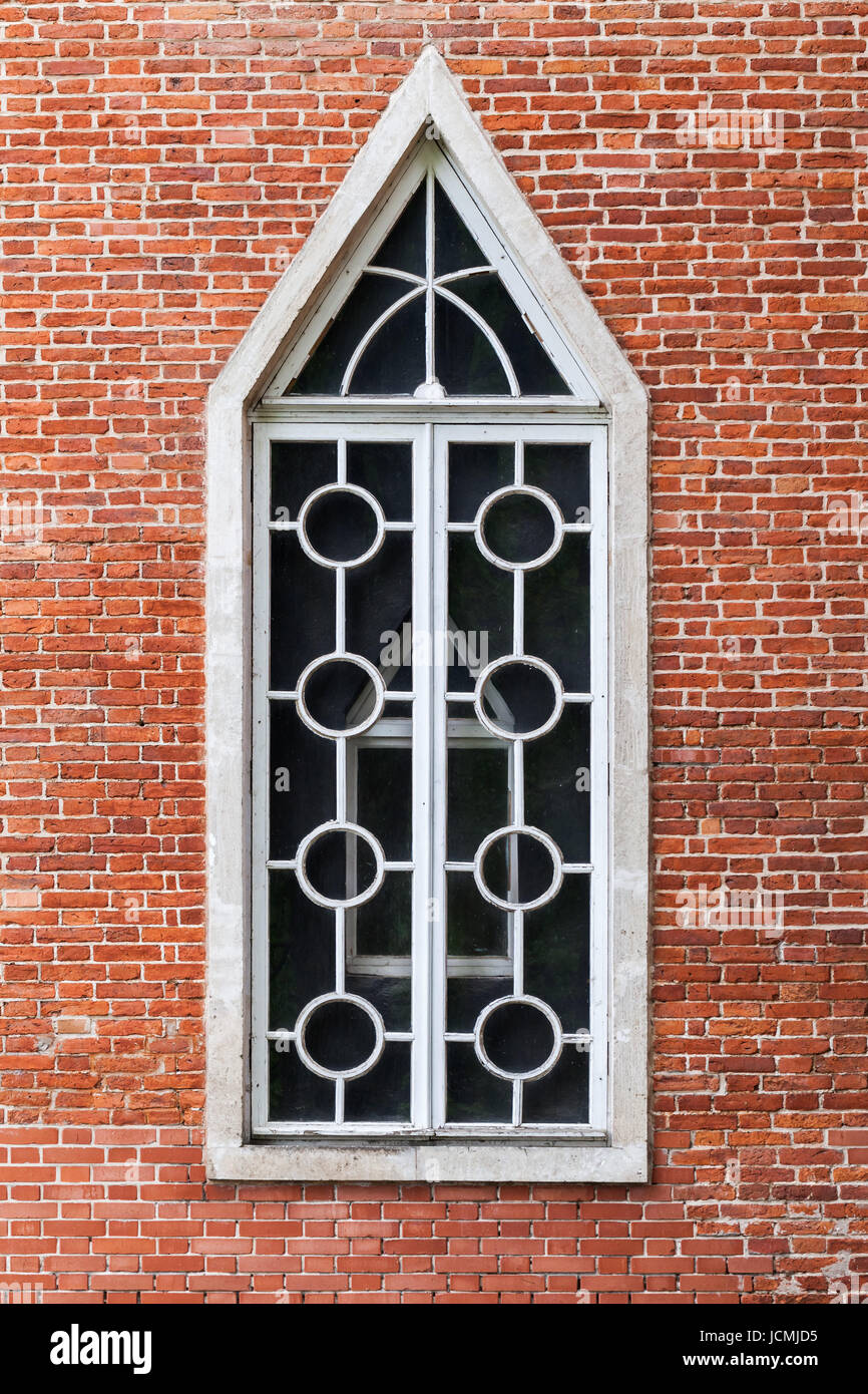 Fenster im roten Backsteinmauer, neugotischen Architektur-Stil. Hintergrundtextur Stockfoto
