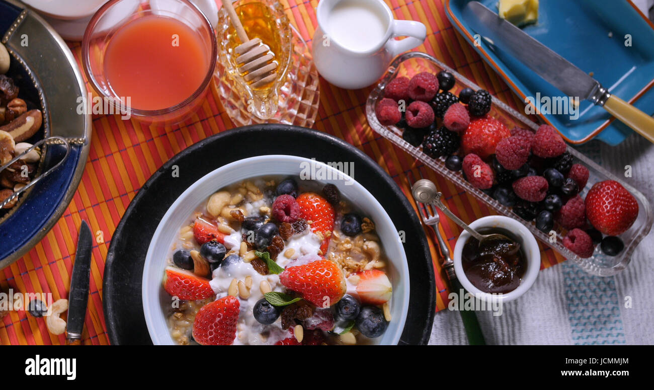 Top-down-Sicht auf ein Frühstück mit Müsli mit Beeren, getrocknete Früchte, Milch und Sahne Stockfoto