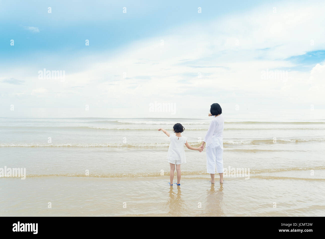 Glücklich asiatischen Familie Mutter und Tochter am Strand suchen und zeigen Sie etwas im Meer. Glückliche Familien-Sommer-Urlaub-Konzept. Stockfoto