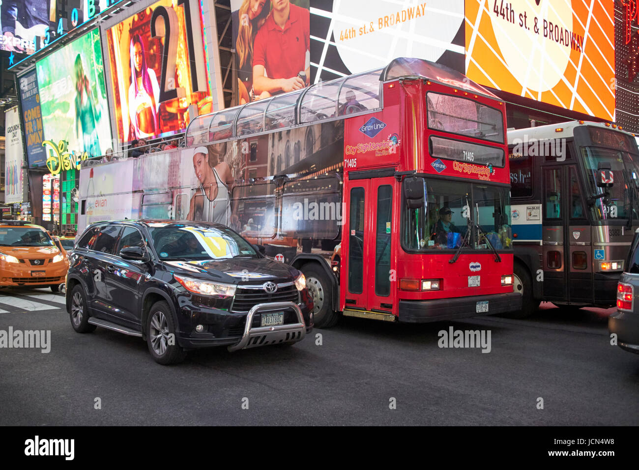 City Sightseeing-Bus auf einen nassen belebten Abend im Times Square New York City USA Stockfoto