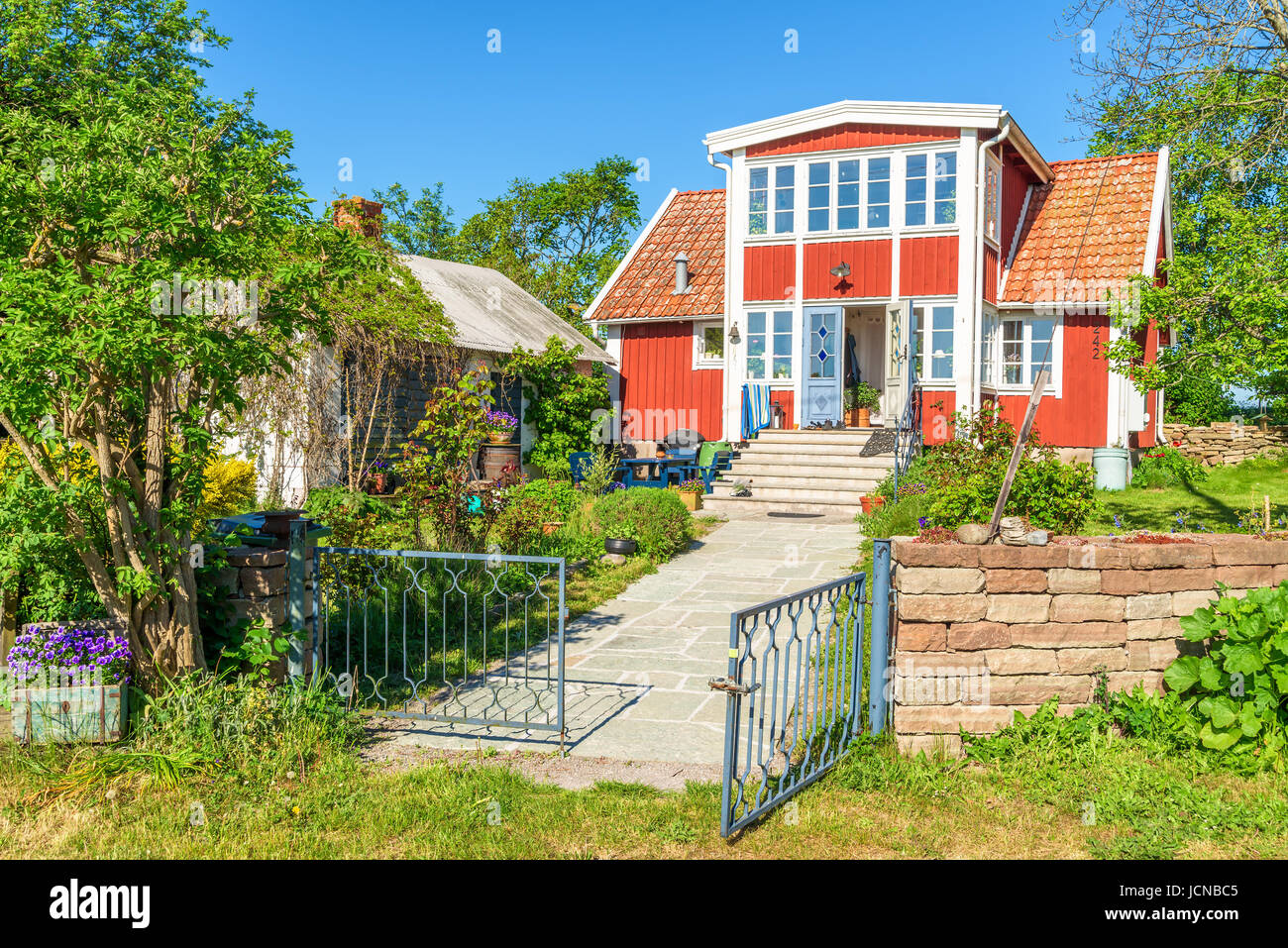 Ossby, Öland, Schweden - 28. Mai 2017: Umwelt-Dokumentarfilm. Schöne rote Haus und Garten in der kleinen Küstenstadt Dorf Ossby an einem sonnigen Tag. Stockfoto