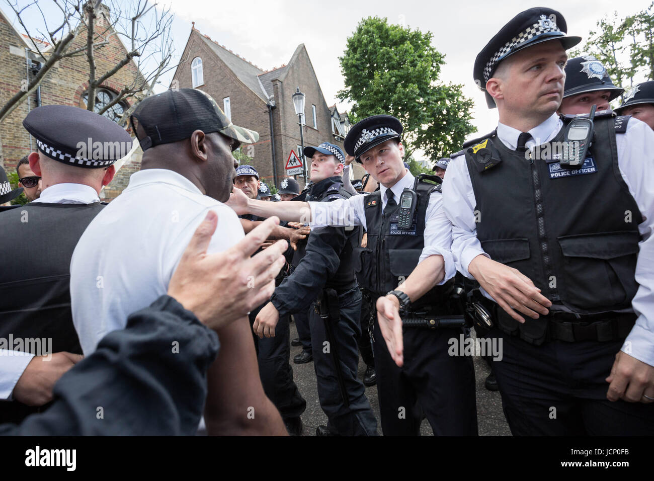 London, UK. 16. Juni 2017. Wütendere Schlägereien mit einheimischen und der Polizei als PM Theresa May verläßt St Clement Kirche auf Treadgold Straße in aller Eile ohne zu sprechen für die Bewohner über das Feuer im nahe gelegenen Grenfell Tower. © Guy Corbishley/Alamy Live-Nachrichten Stockfoto