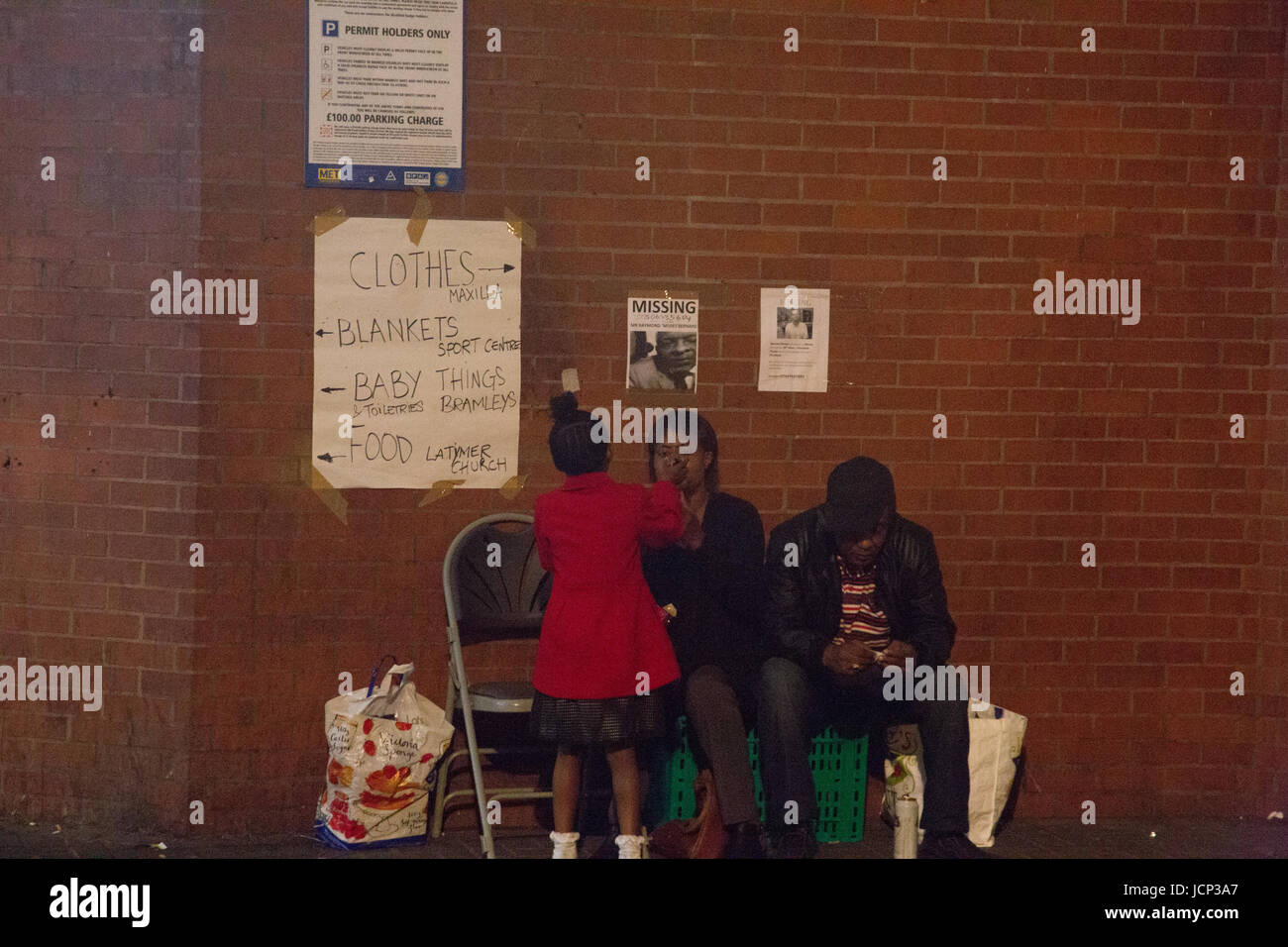 London, UK. 16. Juni 2017. Eine Familie sitzen auf Stühlen während Vigil Menschen fordern Gerechtigkeit für die betroffenen durch das Feuer, das Grenfell Tower, einem Turm Wohngebäude in West London ausgenommen. Bildnachweis: Thabo Jaiyesimi/Alamy Live-Nachrichten Stockfoto