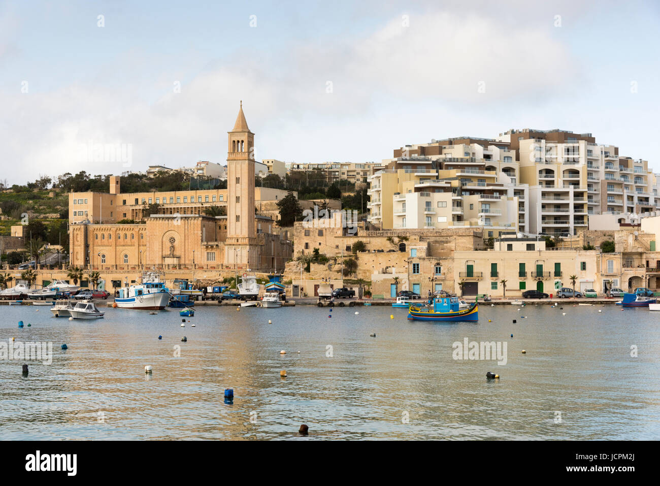 Gebäude und Ferienwohnungen und die Pfarrkirche am Hafen in Marsaskala Malta Stockfoto
