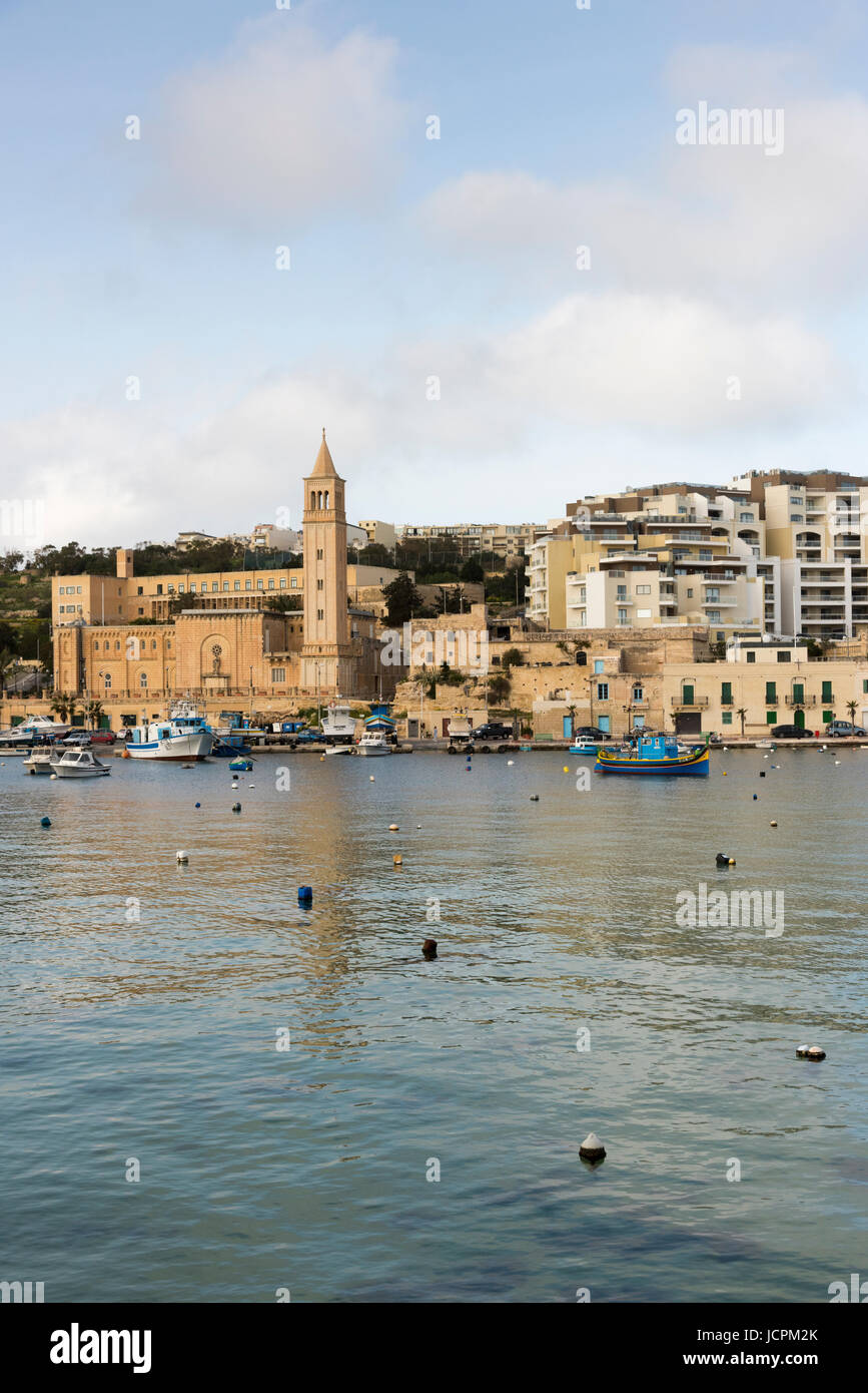 Gebäude und Ferienwohnungen und die Pfarrkirche am Hafen in Marsaskala Malta Stockfoto