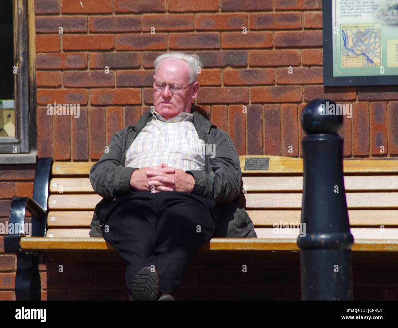Ein älterer Herr döst aus auf einer Bank am Exeter Quay. Devon, UK. Juni 2017. Stockfoto