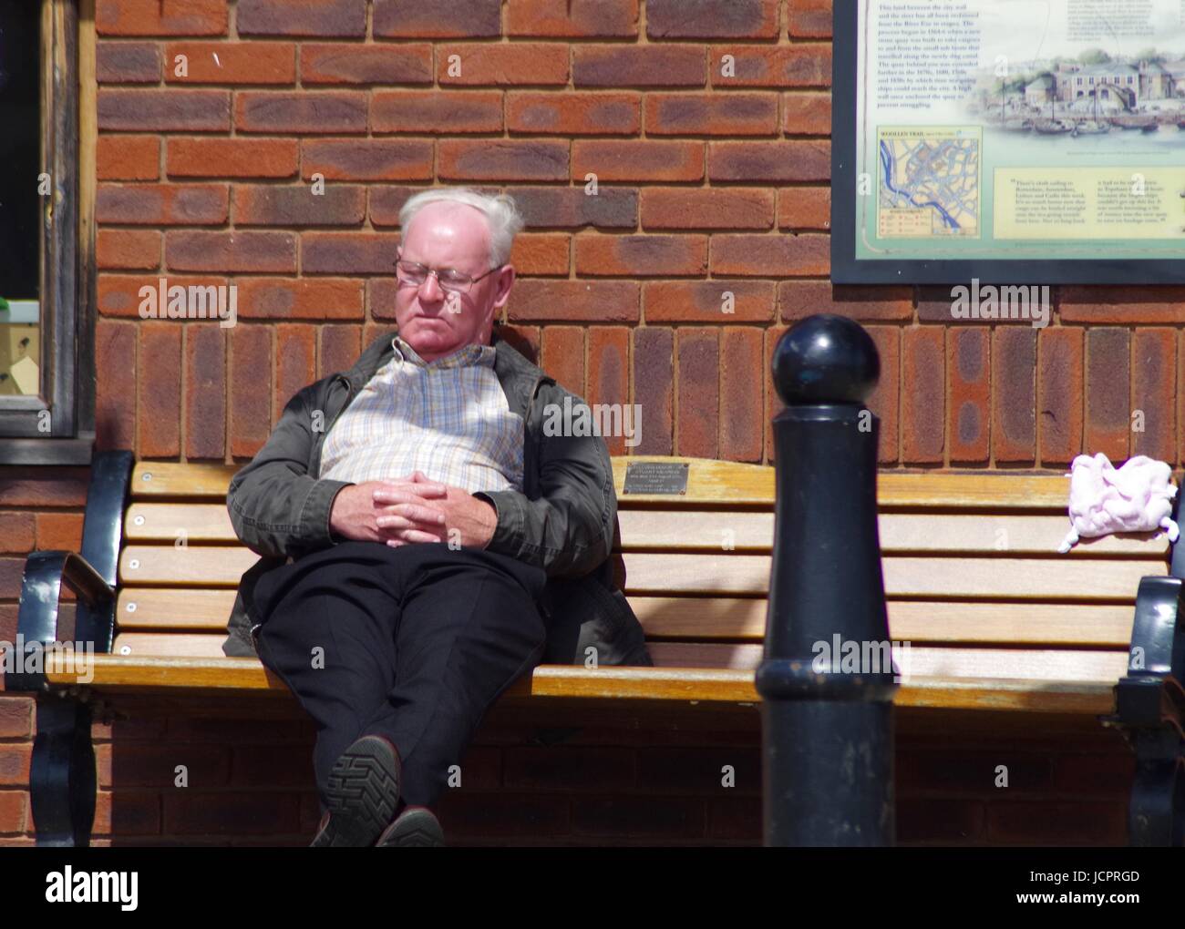 Ein älterer Herr döst aus auf einer Bank am Exeter Quay. Devon, UK. Juni 2017. Stockfoto