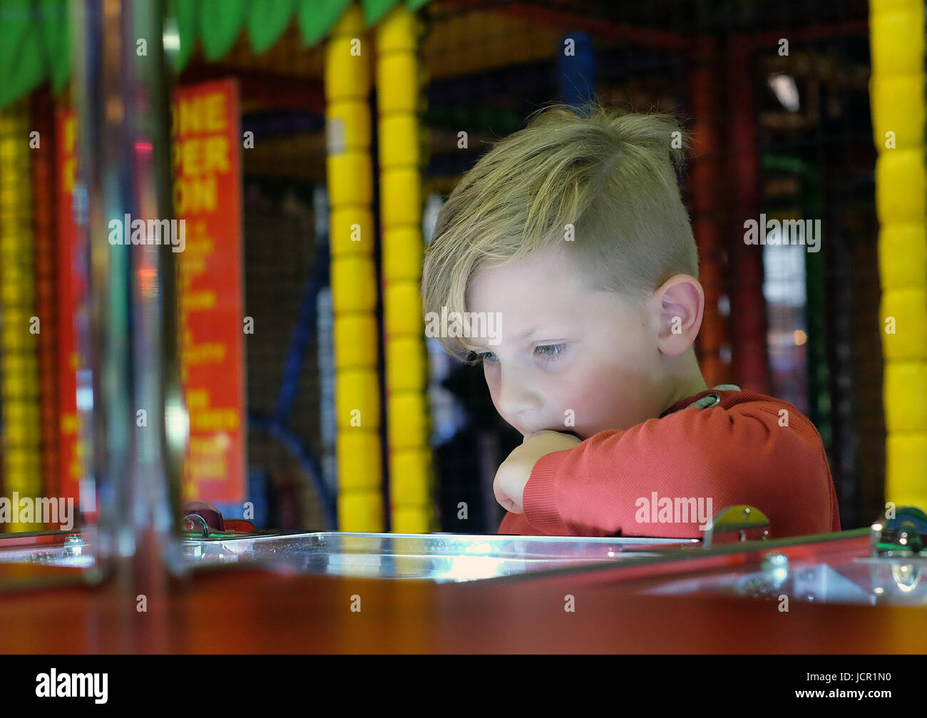 Kind genießen Geldspielautomaten in Spielhallen. Stockfoto