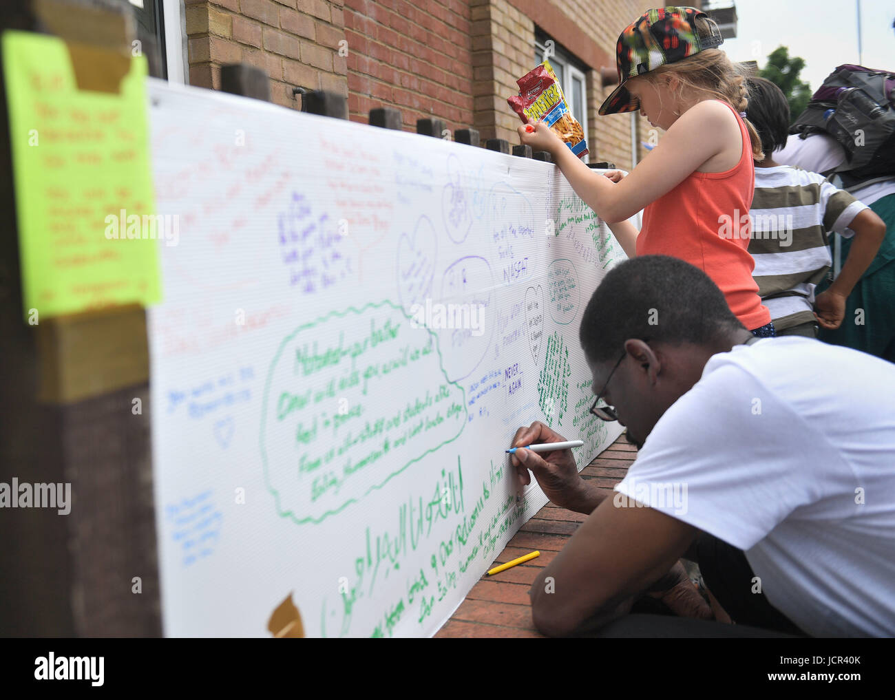Leute schreiben Ehrungen in der Nähe von Grenfell Turm im Westen Londons, nachdem ein Feuer verschlungen das 24-geschossige Gebäude am Mittwochmorgen. Stockfoto