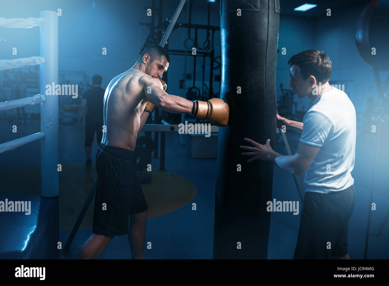 Mann in schwarz Boxbandagen Übungen mit Tasche im Fitness-Studio. Boxtraining, Herren sport Stockfoto