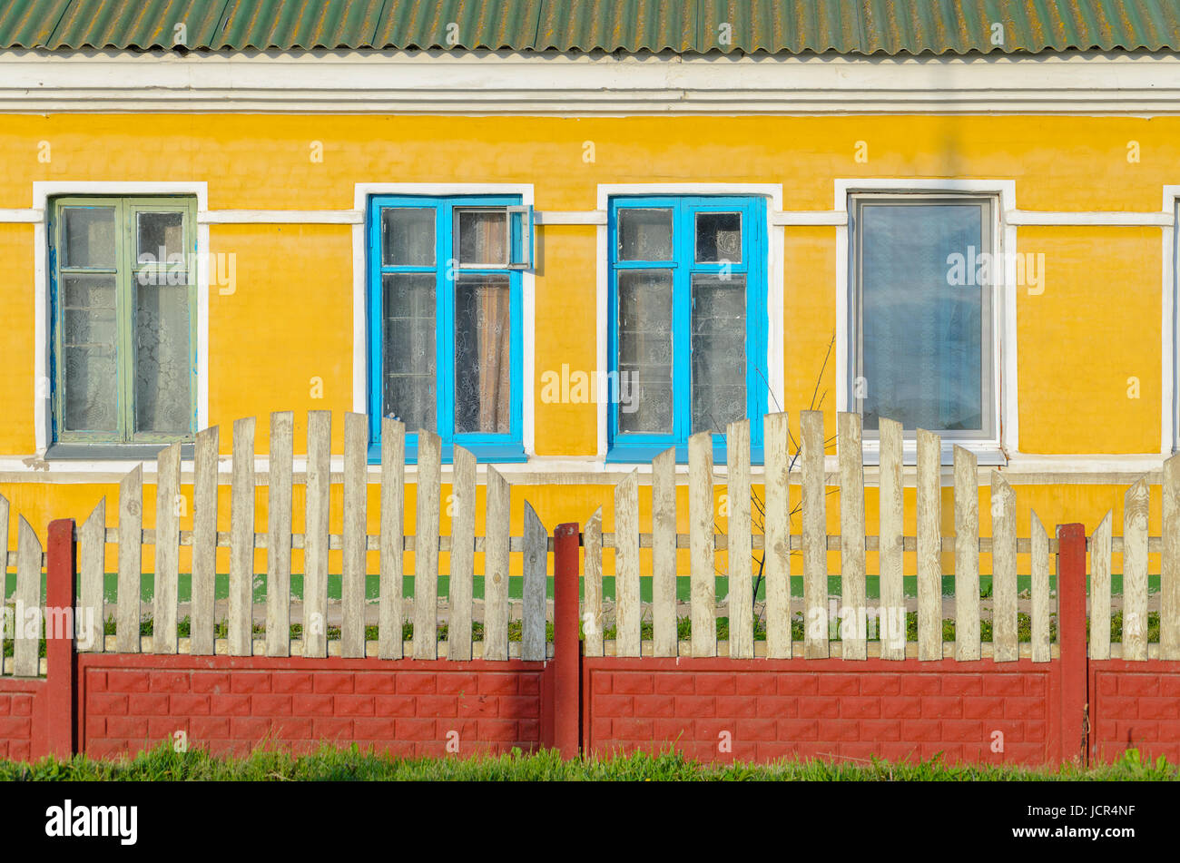 Gelbe Wand mit blauen alte Fensterrahmen. Gelbe Fassade des privaten Stockfoto