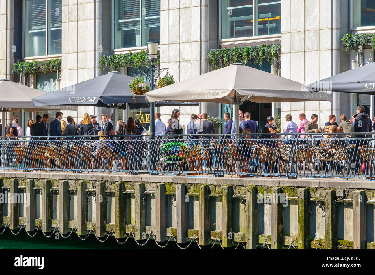 London, UK - 10. Mai 2017 - Dockside Bar in Canary Wharf voll mit Menschen, die an einem sonnigen Tag trinken Stockfoto