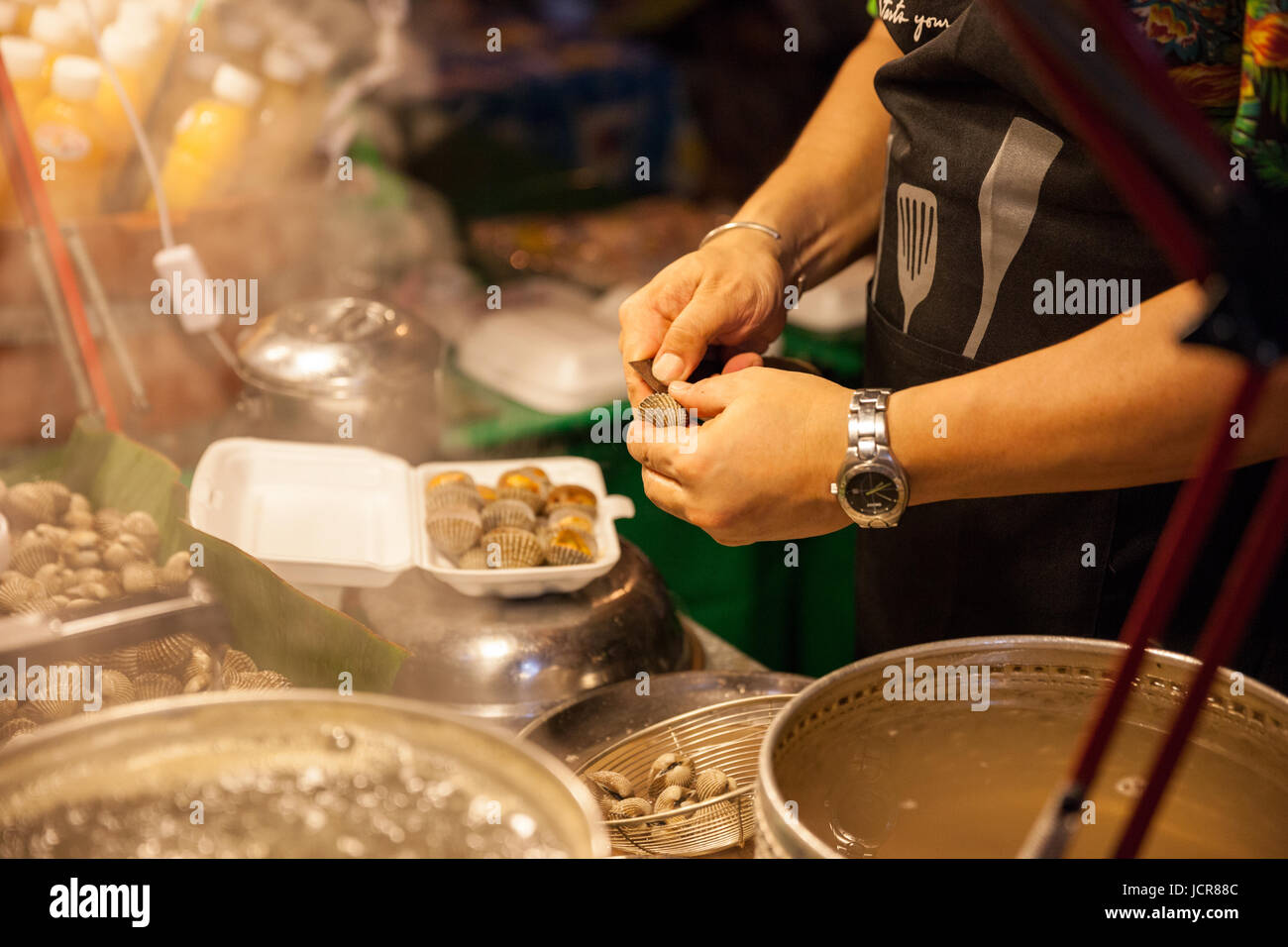 CHIANG MAI, THAILAND - 27 AUGUST: Mann bereiten Muscheln zum Verkauf auf dem Sonntagsmarkt (Walking Street) am 27. August 2016 in Chiang Mai, Thailand. Stockfoto